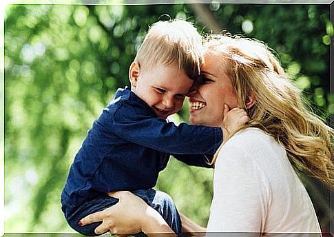 Mother carrying her child on her lap, playing and smiling