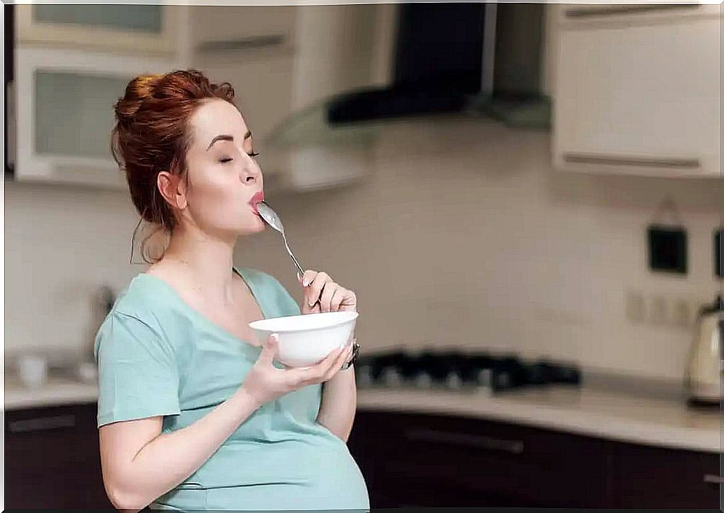 Pregnant woman enjoying while eating during her third trimester of pregnancy.