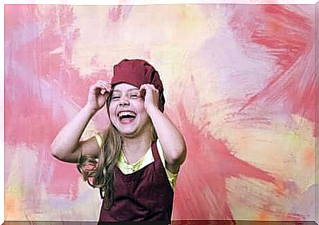 Girl laughing on a red and yellow background.