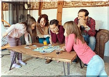 Family playing with board game on vacation.